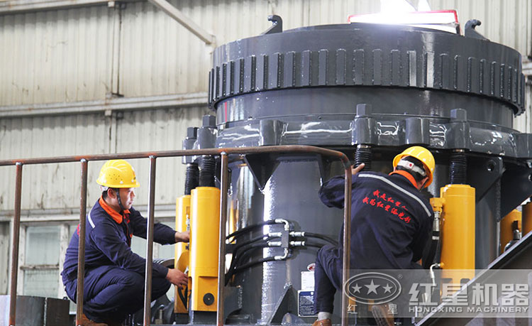 工作人員檢測圓錐破碎機(jī)，保障生產(chǎn)的設(shè)備都有高質(zhì)量